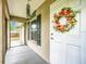 Welcoming front entryway featuring a decorative wreath, a screened entry, and view of the home's interior at 12181 Se 87Th Ct, Belleview, FL 34420