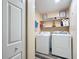 Functional laundry room with washer, dryer, wood-look vinyl flooring, and shelving for storage at 12181 Se 87Th Ct, Belleview, FL 34420
