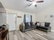 Inviting living room featuring vaulted ceilings, modern flooring, and a stylish gray sectional sofa with decorative pillows at 12181 Se 87Th Ct, Belleview, FL 34420