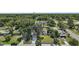 Aerial view of charming home in a lush, green neighborhood with mature trees and well-manicured lawns at 126 E Beach St, Groveland, FL 34736