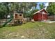 Backyard featuring a playhouse and red storage shed at 126 E Beach St, Groveland, FL 34736