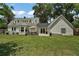 Expansive backyard with patio seating, mature trees, and manicured lawn at 126 E Beach St, Groveland, FL 34736