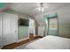 Bedroom featuring hardwood floors, a ceiling fan, and a flat-screen TV mounted on the wall at 126 E Beach St, Groveland, FL 34736