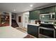 Contemporary kitchen with stainless steel appliances, green cabinets, and white countertops at 126 E Beach St, Groveland, FL 34736