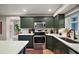 Stylish kitchen featuring stainless steel appliances, green cabinetry, and white countertops at 126 E Beach St, Groveland, FL 34736
