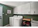 Well-lit laundry room featuring a white washer and dryer, storage cabinets, and a sink at 126 E Beach St, Groveland, FL 34736