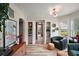 Stylish sitting room features a retro cabinet, unique artwork, and large windows for a cozy atmosphere at 126 E Beach St, Groveland, FL 34736
