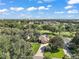 Expansive aerial view of a home site with a well-manicured lawn, mature trees, and a view of the golf course at 13 Hickory Head Hammock, The Villages, FL 32159