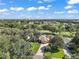 Expansive aerial view of a home site with a well-manicured lawn, mature trees, and a view of the golf course at 13 Hickory Head Hammock, The Villages, FL 32159