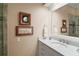Bright bathroom with a marble countertop vanity, stylish fixtures, and decorative seaside themed wall art at 13 Hickory Head Hammock, The Villages, FL 32159