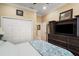 Bedroom with a built-in dresser and TV, closet with folding doors, and light-colored walls and trim at 13 Hickory Head Hammock, The Villages, FL 32159