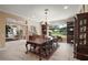 Elegant dining room with a large wooden table, chandelier, and views of the landscaped backyard at 13 Hickory Head Hammock, The Villages, FL 32159