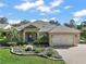 Beautiful home with manicured lawn and landscaping, featuring an attached garage and inviting curb appeal at 13 Hickory Head Hammock, The Villages, FL 32159