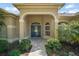 Elegant home entrance with a beautiful blue door and manicured landscaping at 13 Hickory Head Hammock, The Villages, FL 32159