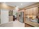 Modern kitchen featuring wood cabinets, granite countertops, stainless steel appliances, and tile flooring at 13 Hickory Head Hammock, The Villages, FL 32159