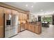 Bright kitchen featuring wood cabinets, tile flooring, granite countertops, and stainless steel appliances at 13 Hickory Head Hammock, The Villages, FL 32159