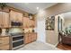 Charming kitchen featuring wood cabinets, tile flooring, granite countertops, and stainless steel appliances at 13 Hickory Head Hammock, The Villages, FL 32159