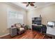 Bright office features hardwood floors, plantation shutters, a computer, and a comfortable accent chair at 13 Hickory Head Hammock, The Villages, FL 32159