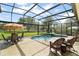 A screened pool with outdoor seating and an expansive fenced yard at 13 Hickory Head Hammock, The Villages, FL 32159