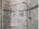 Tiled shower featuring a showerhead, seamless glass enclosure, shampoo niches, and a stylish design at 13 Hickory Head Hammock, The Villages, FL 32159