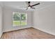 Bright bedroom with hardwood floors, large window, and ceiling fan at 13334 Sw 107Th St, Dunnellon, FL 34432