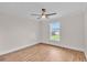 Bright bedroom featuring a ceiling fan, hardwood floors, and a large window with backyard view at 13334 Sw 107Th St, Dunnellon, FL 34432