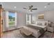 Comfortable bedroom with a bed, bedside tables and bright windows looking to the yard at 13334 Sw 107Th St, Dunnellon, FL 34432