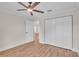 Bright bedroom featuring a ceiling fan, hardwood floors, and a large closet at 13334 Sw 107Th St, Dunnellon, FL 34432