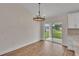 Open dining area with wood flooring, modern chandelier and sliding glass doors to the patio at 13334 Sw 107Th St, Dunnellon, FL 34432