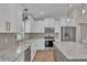Well-lit kitchen showcasing a center island, white cabinetry, and modern stainless steel appliances at 13334 Sw 107Th St, Dunnellon, FL 34432