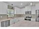 Bright kitchen showcasing white cabinetry, marble countertops, and stainless steel appliances at 13334 Sw 107Th St, Dunnellon, FL 34432