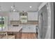Modern kitchen with white cabinets, stainless appliances, island seating, and backyard access at 13334 Sw 107Th St, Dunnellon, FL 34432