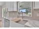 Stylish kitchen sink area with marble countertops, neutral backsplash, and modern faucet at 13334 Sw 107Th St, Dunnellon, FL 34432