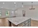 Open-concept kitchen featuring a marble island, pendant lighting, and wood-look flooring at 13334 Sw 107Th St, Dunnellon, FL 34432