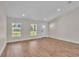 An open-concept living room featuring wood flooring and a bright entry door at 13334 Sw 107Th St, Dunnellon, FL 34432