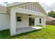 Back patio with ceiling fan and sliding glass doors to lawn at 13334 Sw 107Th St, Dunnellon, FL 34432