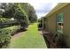 Manicured backyard featuring lush green grass, a wooden fence, and mature landscaping at 1335 Eureka Mill Run, The Villages, FL 32162