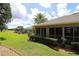 The spacious backyard has beautifully maintained landscaping with lush lawns, a pool, and mature trees at 1335 Eureka Mill Run, The Villages, FL 32162
