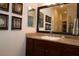 Bathroom featuring a vanity with granite countertop, decorative mirror, and warm lighting at 1335 Eureka Mill Run, The Villages, FL 32162
