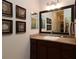 A well-lit bathroom features a large vanity with a granite countertop and an decorative mirror at 1335 Eureka Mill Run, The Villages, FL 32162