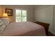 Bedroom showcasing shuttered windows with views of lush greenery and a spacious closet for ample storage at 1335 Eureka Mill Run, The Villages, FL 32162
