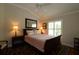 This bedroom boasts warm lighting, a large mirror, and a cozy queen sized bed at 1335 Eureka Mill Run, The Villages, FL 32162