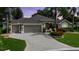 Charming single-story home with a three-car garage, beautiful landscaping, and mature palm trees in a suburban neighborhood at 1335 Eureka Mill Run, The Villages, FL 32162