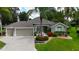 Charming single-story home with a two-car garage, lush landscaping, and a well-manicured lawn at 1335 Eureka Mill Run, The Villages, FL 32162