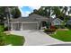 Charming single-story home with a three-car garage, beautiful landscaping, and mature palm trees in a suburban neighborhood at 1335 Eureka Mill Run, The Villages, FL 32162