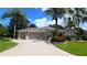 Charming single-story home with a three-car garage, beautiful landscaping, and mature palm trees in a suburban neighborhood at 1335 Eureka Mill Run, The Villages, FL 32162