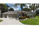 Charming single-story home with a three-car garage, beautiful landscaping, and mature palm trees in a suburban neighborhood at 1335 Eureka Mill Run, The Villages, FL 32162