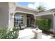 Inviting front porch featuring comfortable seating and decorative pineapple, framed by lush greenery and an arched entryway at 1335 Eureka Mill Run, The Villages, FL 32162