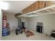 A large garage area with an organizational system including overhead shelving, ladders, and tools at 1335 Eureka Mill Run, The Villages, FL 32162
