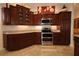 Gourmet kitchen with stainless steel appliances, granite countertops, and rich wood cabinetry at 1335 Eureka Mill Run, The Villages, FL 32162